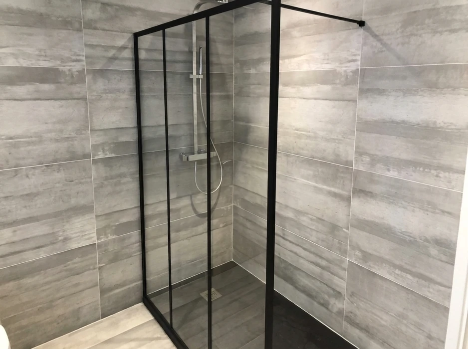 Cabine de douche d'angle moderne, parois en verre transparent à cadre noir mat, style industriel