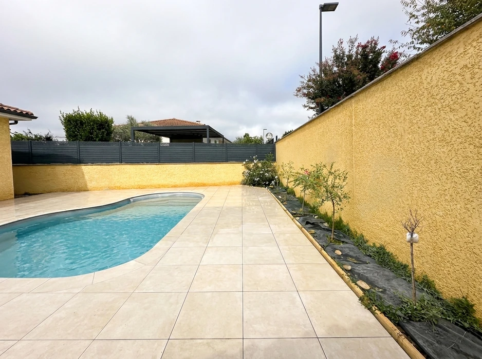 Piscine extérieure à fond coquille en béton projeté, forme libre, revêtement intérieur blanc, eau turquoise