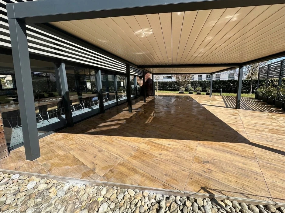 Terrasse extérieure couverte par une pergola bioclimatique à lames orientables en aluminium anthracite