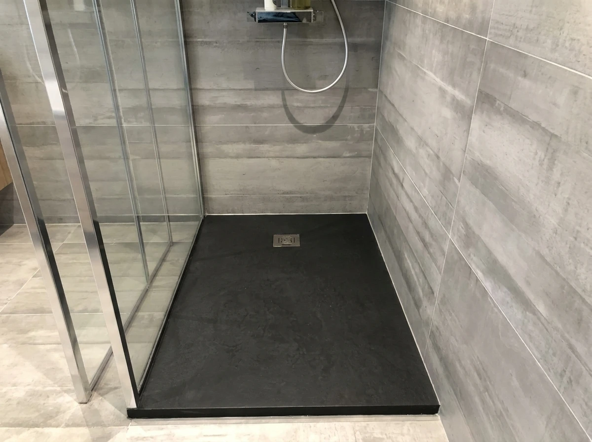 Douche à l'italienne moderne avec parois en grand carrelage grès cérame effet béton anthracite, format 60x120 cm, joints gris fins