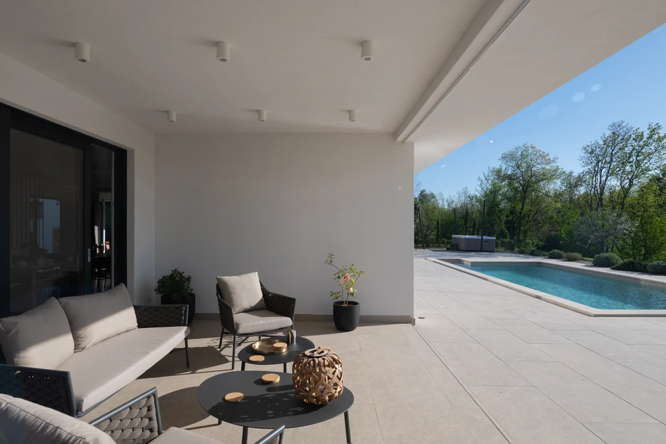 Terrasse extérieure avec carrelage imitation bois, pose en chevron à l'angle, joints fins gris