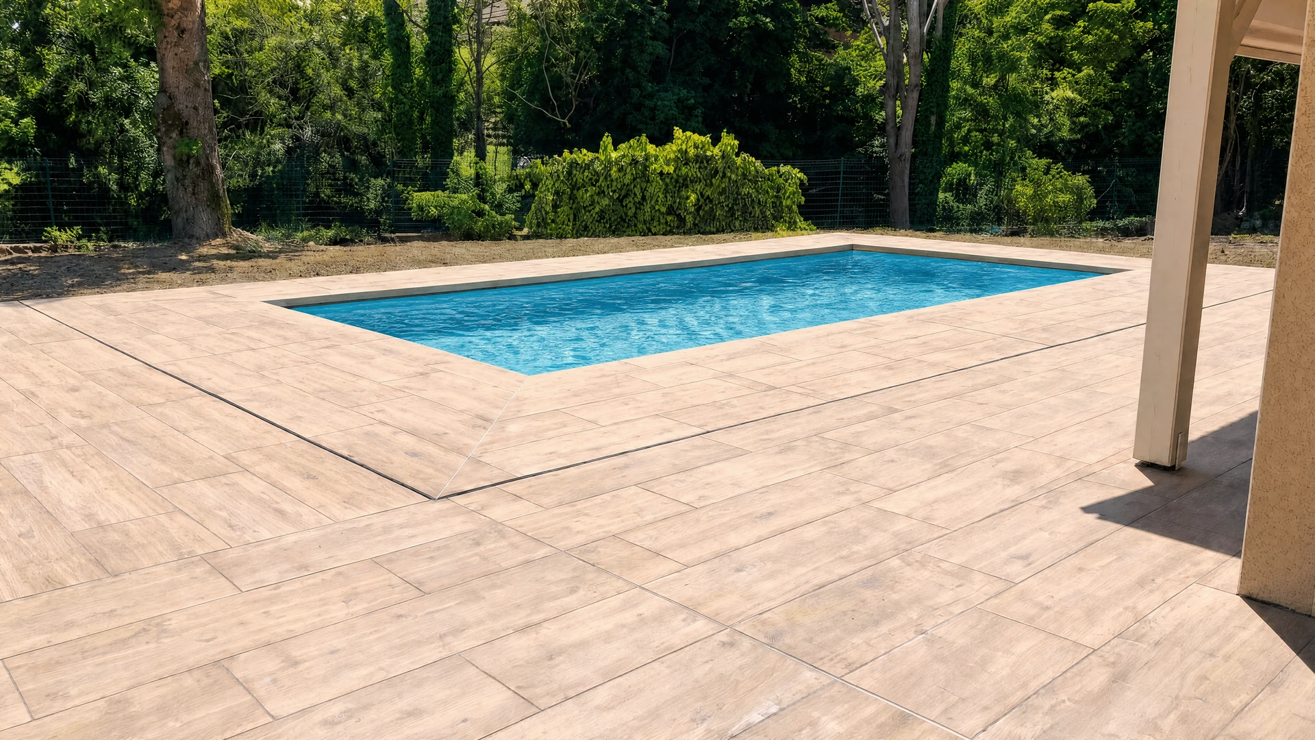 Terrasse extérieure avec piscine à débordement rectangulaire intégrée dans un deck en bois composite